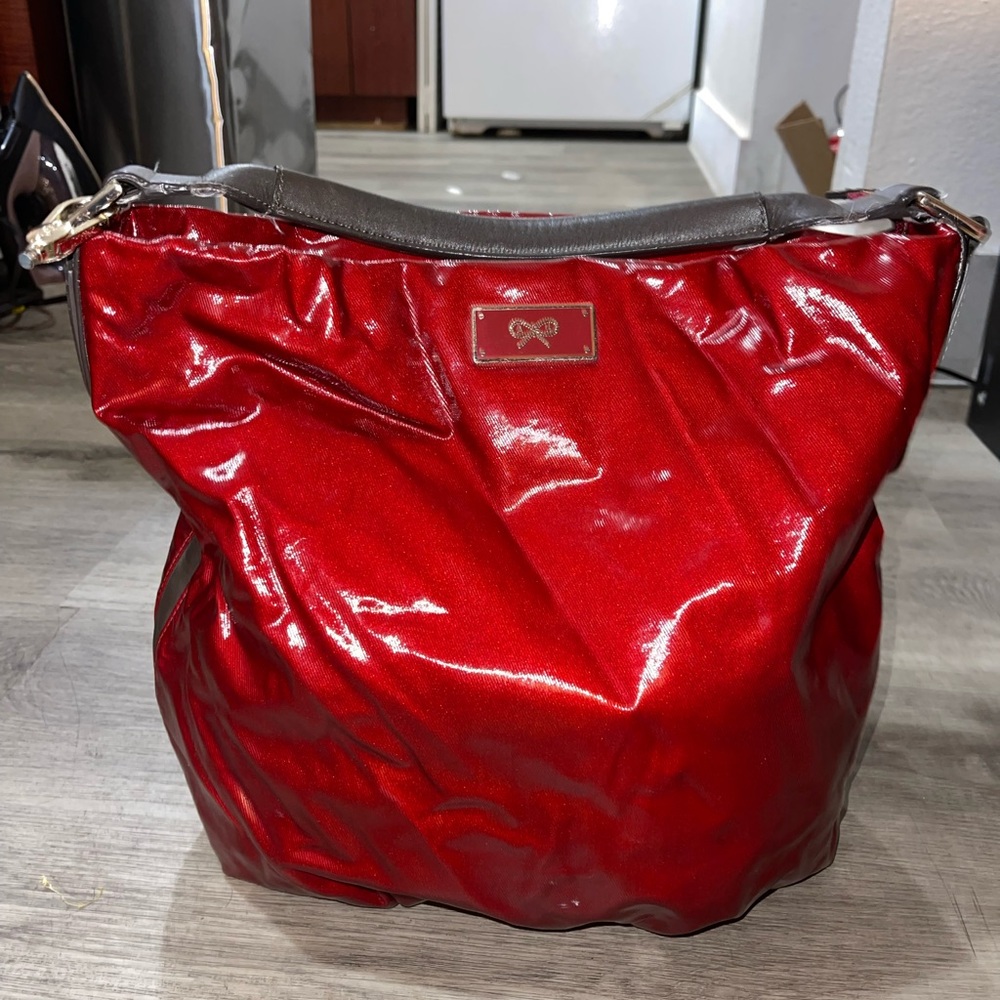 - Anya Hindmarch red patent leather bag with gold accent